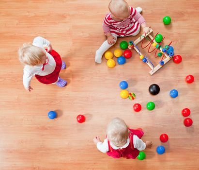 Top view of three little girls playing on the floor