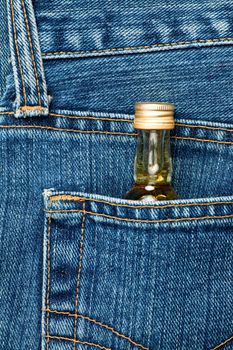 Blue jeans pocket with small bottle of alcohol