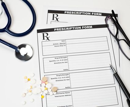 Blank veterinarian prescription form with stethoscope pills glasses and pen
