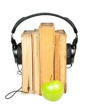 HI-Fi headphones on stack of old books with green apple on white background