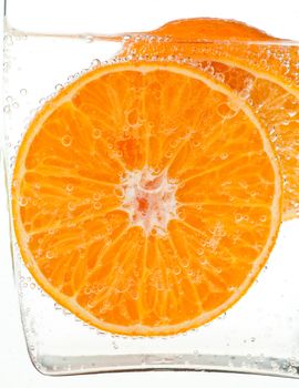 Orange slice in water with bubbles