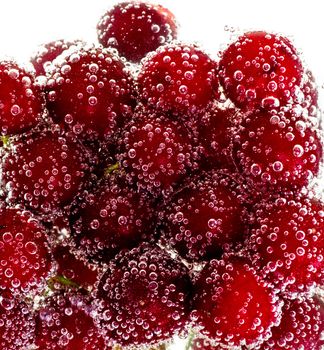 Heap of cherries in water with bubbles