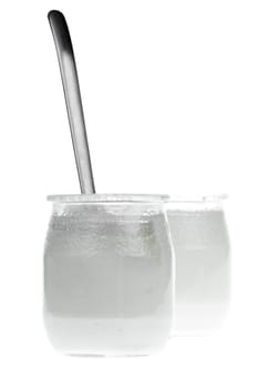 Old-fashioned yogurt jars with spoon on white background