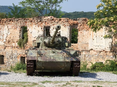 old army tank infront of burned house