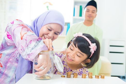 Southeast Asian family saving money at home. Muslim family living lifestyle.