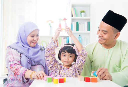 Southeast Asian child achievement. Muslim family playing games.