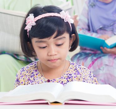 Muslim family living lifestyle. Southeast asian family reading book.