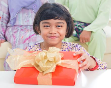 Ssoutheast Asian girl with birthday present. Muslim family living lifestyle.