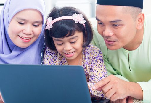 Southeast Asian family browsing internet at home. Muslim family living lifestyle