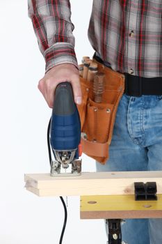 A cropped picture of a handyman using a jigsaw.