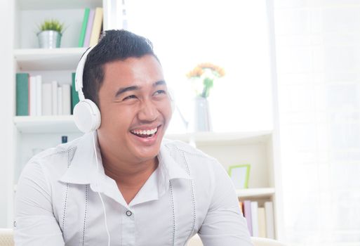 Attractive Southeast Asian man listen mp3 at home