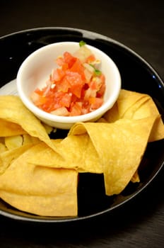 Fried potatoes orderves with tomato in black dish