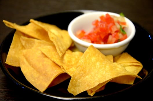 Fried potatoes orderves with tomato in black dish