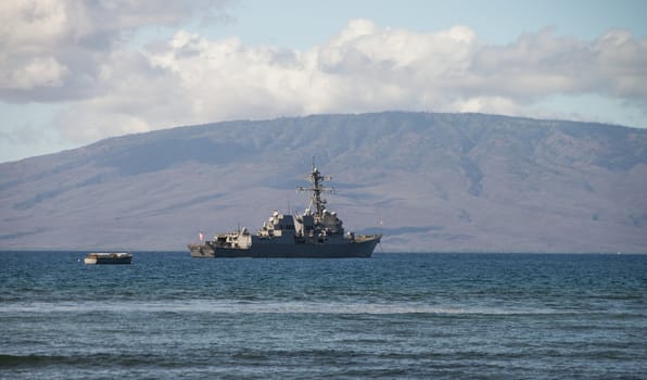 United States Navy Ship anchored off the coast of Maui, Hawaii.  The island of Lanai in background