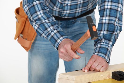 Man hammering nail into wood