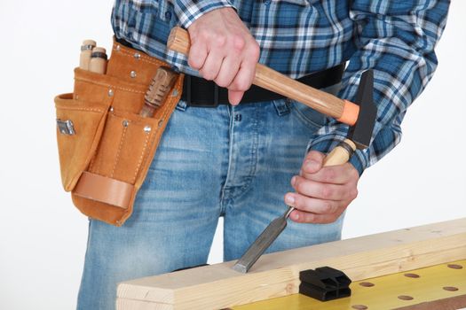 Tradesman chiseling a plank of wood