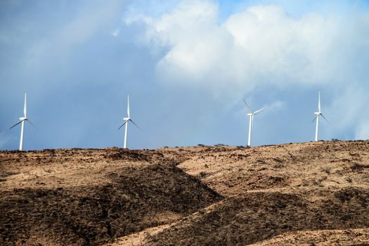 Wind turbines above the coastline in Maui, Hawaii