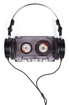 Compact headphones with audio cassette on white background