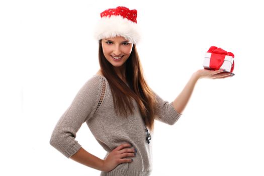 Beautiful girl smiling in christmas hat and holding gift over a white background