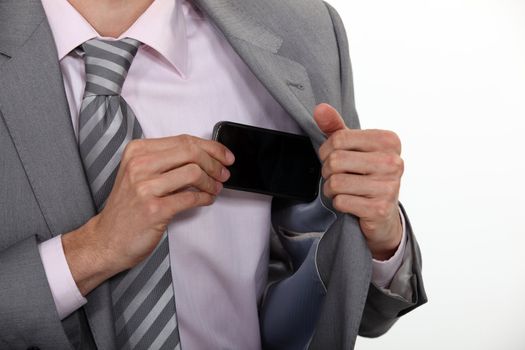 Businessman putting his mobile phone into his pocket