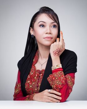 Beautiful muslim lady wear red with hijab, henna painted on hand