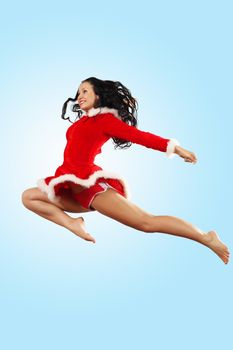 Happy smiling woman in red xmas costume jumping high