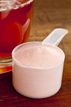 measuring scoop of pomegranate fruit powder and glass of juice