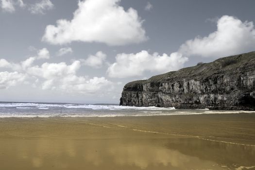 Ballybunion beach and cliffs on the Atlantic coast in Ireland with waves crashing on the cliffs