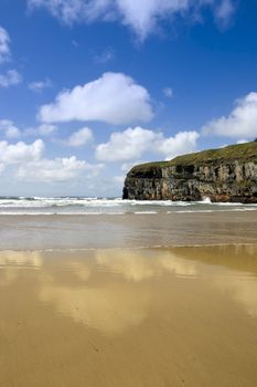 Ballybunion beach and cliffs on the Atlantic coast in Ireland with waves crashing on the cliffs