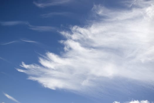 white fluffy clouds and trails against lovely blue sky