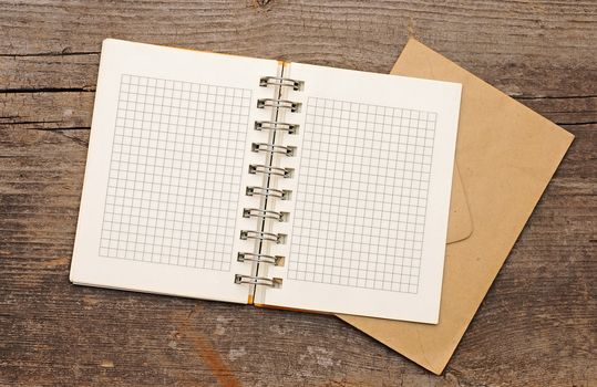 note book with old envelopes on wooden background. With copy space