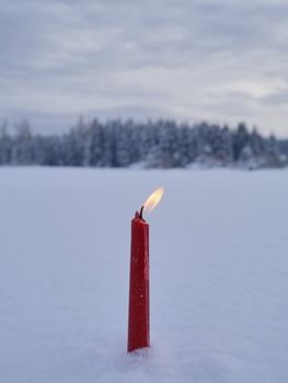 red candles on white snow background outside in winter