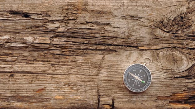 Compass on the old wooden background 