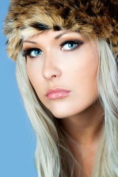 Portrait of a Blonde with a furry hat in the studio