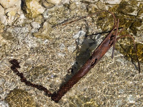 old rusty anchor on the rocky coast