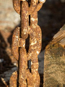 old red  rusty chain near the wooden plank
