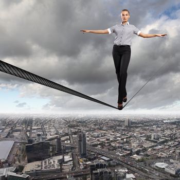 Business woman balancing high over a cityscape