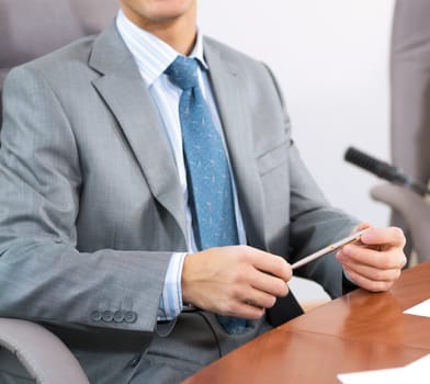 businessman sitting at a table and holding a pen