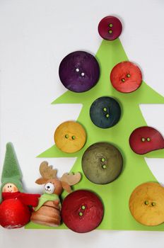 Paper Christmas tree decorated with vivid buttons and funny toys 