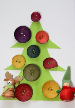 Paper Christmas tree decorated by vivid buttons and funny toys 