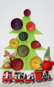 Paper Christmas tree decorated by vivid buttons and funny toys 