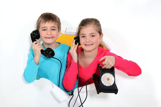 Brother and sister with old-fashioned telephone