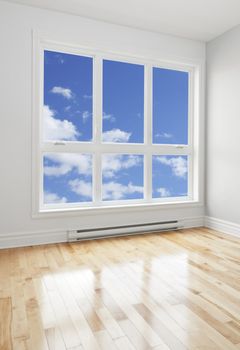 Blue sky seen through the big window of an empty room.