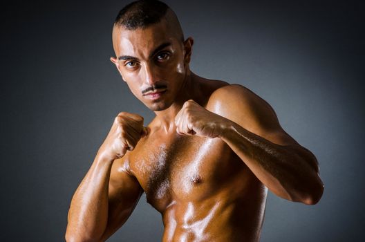 Muscular boxer in dark studio