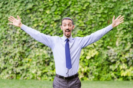 Happy businessman in the forest