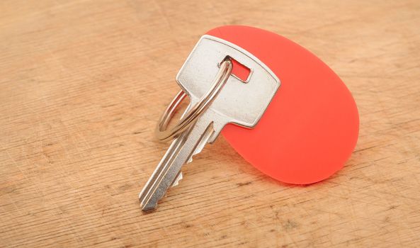 Blank tag and a key on wooden background