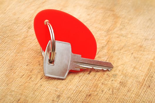 Blank tag and a key on wooden background