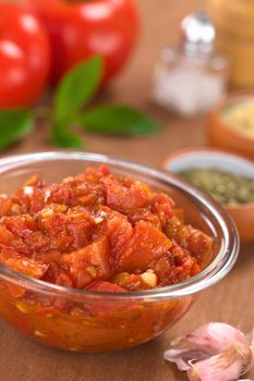 Glass bowl of fresh homemade tomato sauce for pizza made of fresh tomatoes, basil, garlic and oregano (Selective Focus, Focus one third into the tomato sauce)