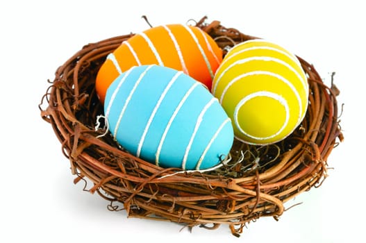 Colored Easter eggs in a nest on a white background.