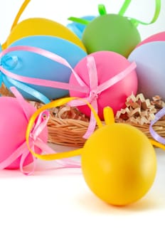 Easter colored eggs in the basket on the white background. Happy Easter! 